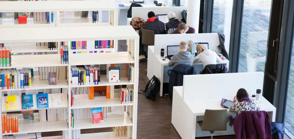 Studierende am Campus Hamm befinden sich in der Bibliothek zum Lernen.
