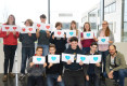 11 Schülerinnen und Schüler halten Herzchen-Schilder hoch