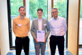 Tobias Brandt (l.) und Prof. Dr.-Ing. Jan Pelzl (r.) gratulieren Marvin Grunwald zum Förderpreis