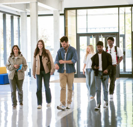 Studierende laufen in einem Hochschulgebäude
